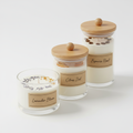Set of 3 scented soy wax candles in glass jars with wooden lids on white background