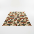 Modern geometric pattern area rug in earthy tones on white background
